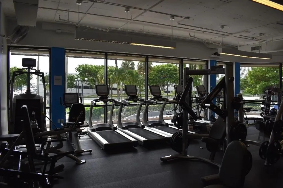 A gym with many machines and windows
