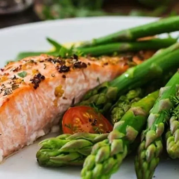 A plate of food with asparagus and tomatoes.